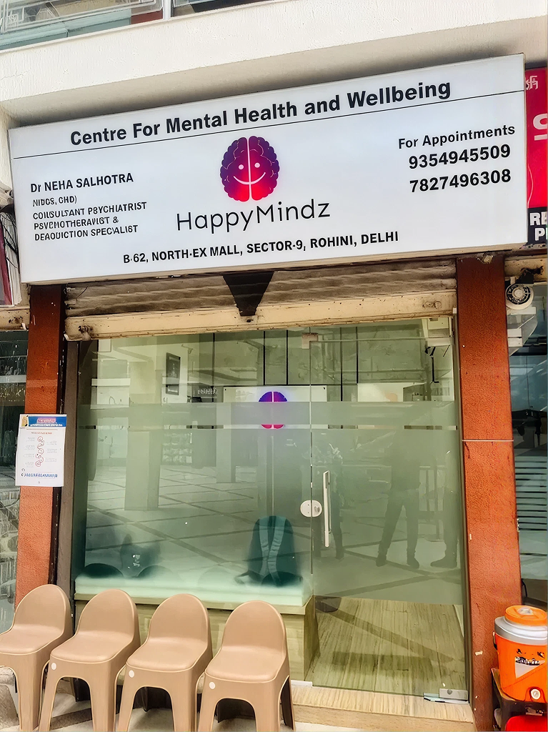 HappyMindz Clinic sign and entrance with chairs outside.